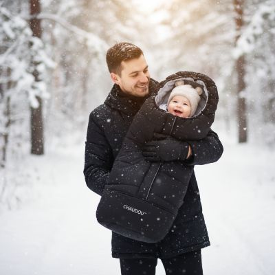 papa avec bebe dans chanceliere en promenade hivernale